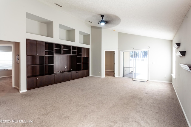 unfurnished living room with ceiling fan, a healthy amount of sunlight, built in features, and a textured ceiling