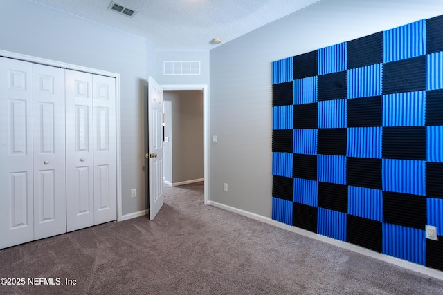 unfurnished bedroom with a textured ceiling, a closet, and carpet flooring