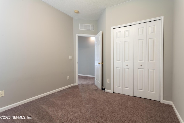 unfurnished bedroom with carpet floors, a closet, and a textured ceiling