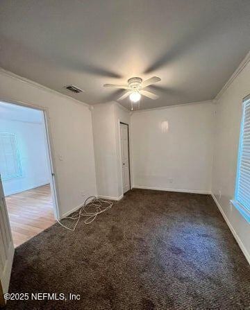 carpeted empty room with ceiling fan and ornamental molding