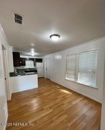 kitchen featuring plenty of natural light, kitchen peninsula, white refrigerator, and wood-type flooring