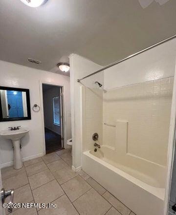 bathroom with tile patterned floors and washtub / shower combination