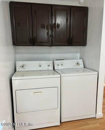 washroom with cabinets, light hardwood / wood-style flooring, and independent washer and dryer