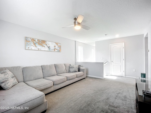 living room featuring ceiling fan, carpet floors, and a textured ceiling