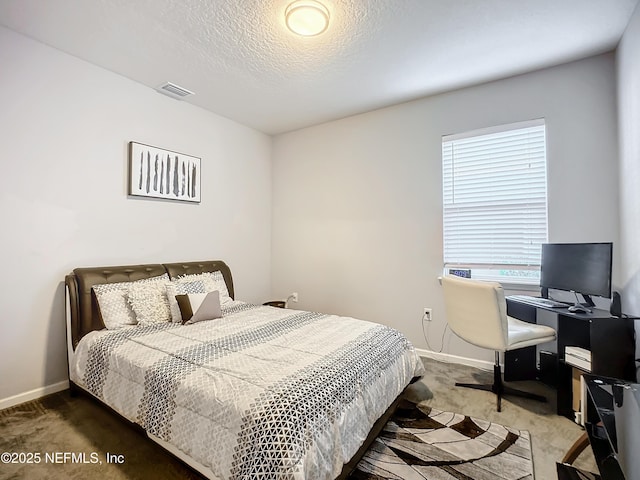 bedroom featuring dark carpet and a textured ceiling