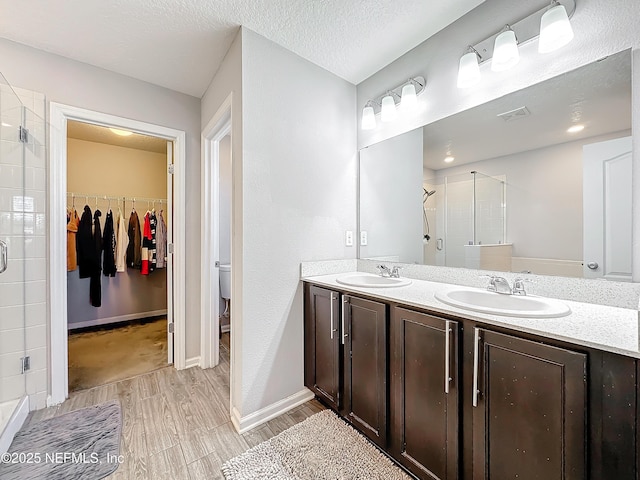 bathroom with toilet, vanity, walk in shower, hardwood / wood-style flooring, and a textured ceiling