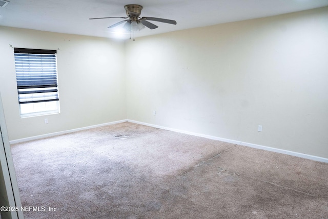 empty room featuring ceiling fan and carpet