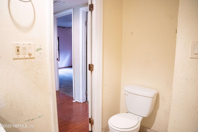 bathroom with toilet and hardwood / wood-style flooring