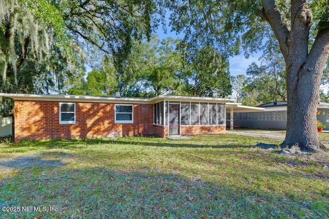 ranch-style home featuring a front lawn and a sunroom