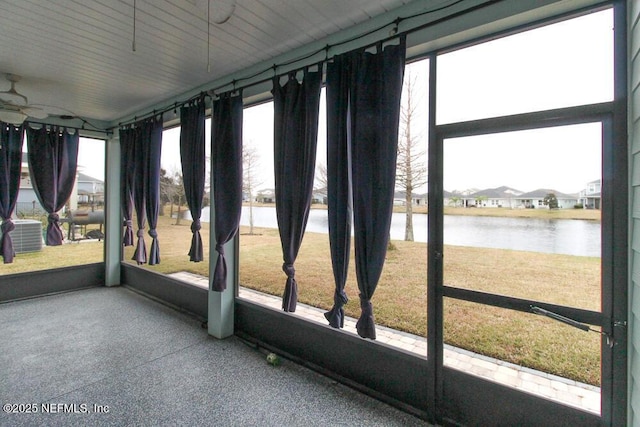 unfurnished sunroom with a water view and ceiling fan