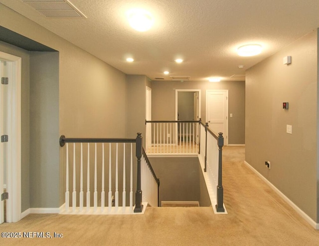 staircase with carpet and a textured ceiling