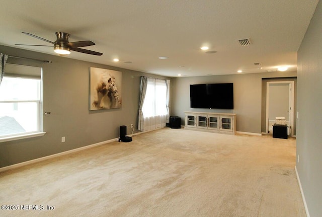 unfurnished living room featuring light carpet and ceiling fan