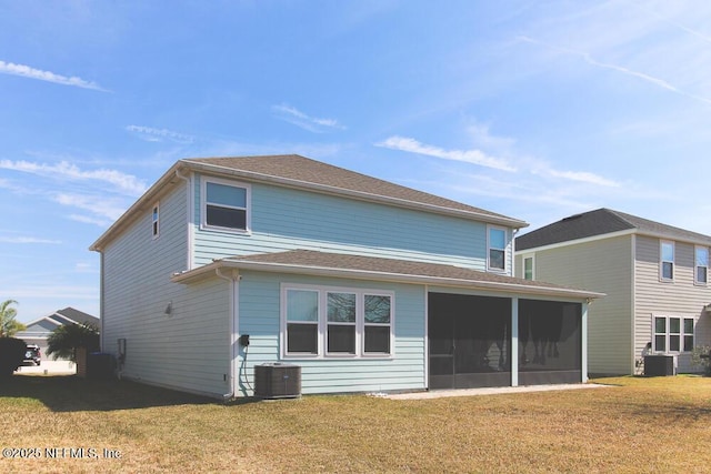 rear view of house featuring a sunroom, central AC, and a lawn