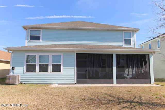 back of property with central AC, a yard, and a sunroom