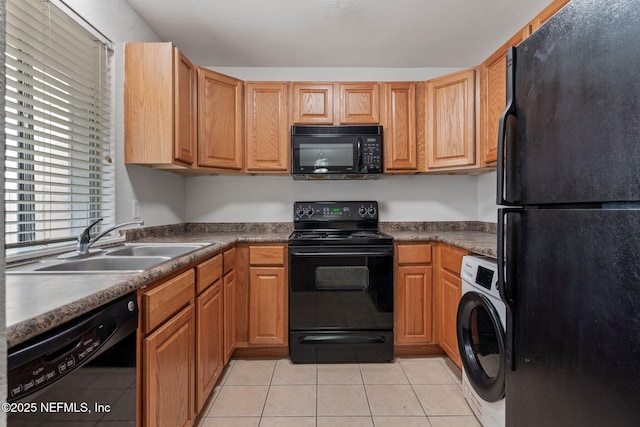 kitchen with light tile patterned floors, sink, washer / clothes dryer, and black appliances