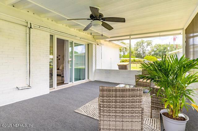 unfurnished sunroom featuring ceiling fan