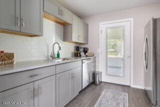 kitchen featuring sink, gray cabinetry, stainless steel appliances, and light hardwood / wood-style floors