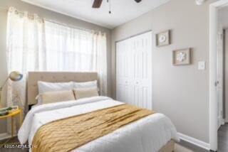 bedroom featuring a closet, multiple windows, and ceiling fan