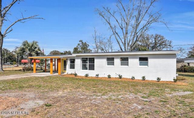 ranch-style house featuring a front yard and a carport