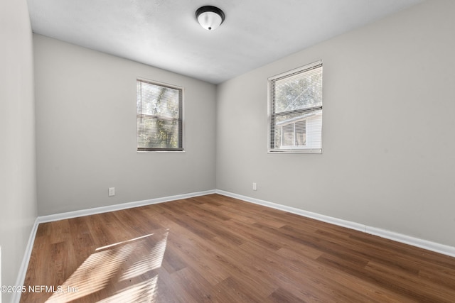 spare room with plenty of natural light and hardwood / wood-style floors