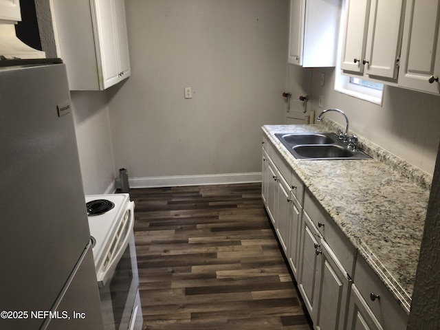 kitchen with dark wood-type flooring, sink, stainless steel refrigerator, electric stove, and white cabinets