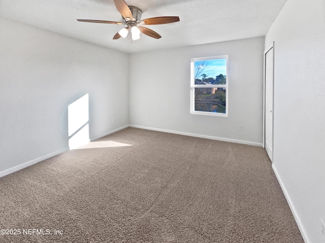 empty room with ceiling fan and carpet flooring