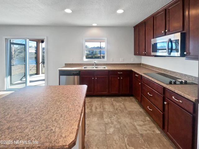 kitchen with sink, a textured ceiling, and stainless steel appliances