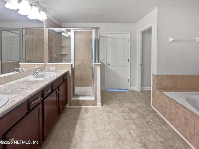 bathroom with plus walk in shower, a textured ceiling, and vanity