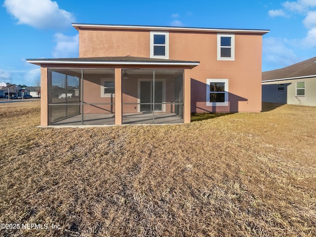 rear view of property featuring a sunroom and a lawn