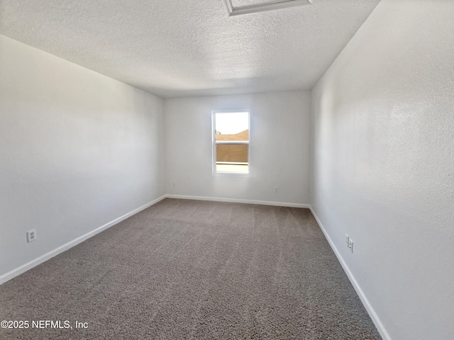 spare room with a textured ceiling and carpet flooring