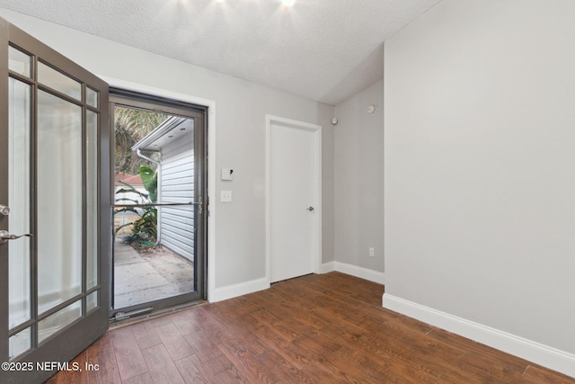 entryway with dark wood-type flooring and a textured ceiling