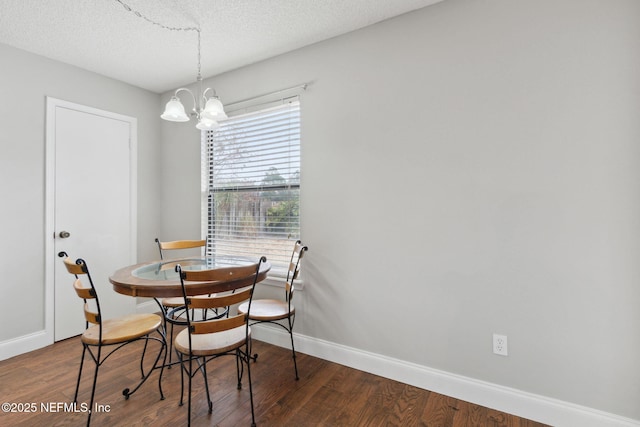 dining area featuring an inviting chandelier, a textured ceiling, and hardwood / wood-style flooring