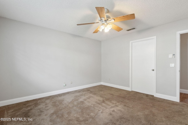 carpeted spare room featuring ceiling fan and a textured ceiling