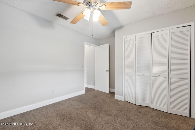 unfurnished bedroom with a textured ceiling, a closet, ceiling fan, and carpet