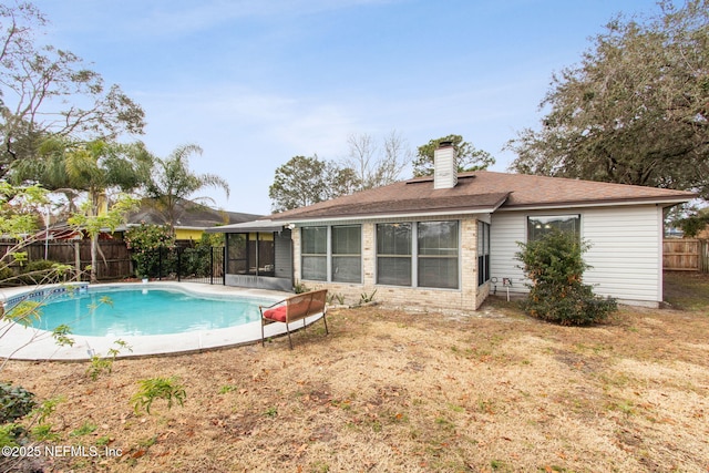 view of pool with a sunroom and a lawn