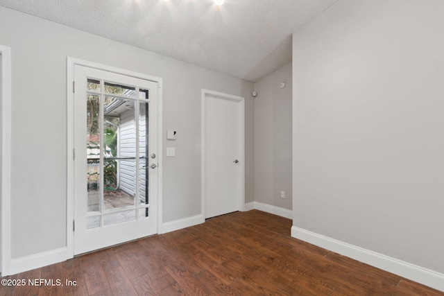 foyer entrance featuring dark wood-type flooring and a textured ceiling