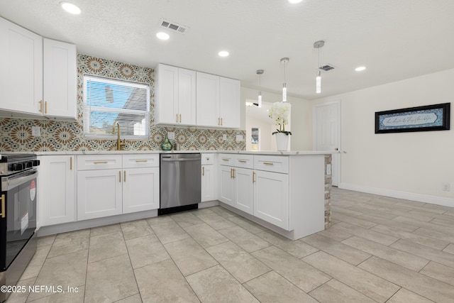 kitchen with appliances with stainless steel finishes, white cabinets, kitchen peninsula, and hanging light fixtures