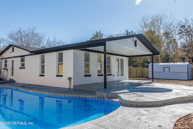 exterior space featuring a shed, a patio area, and an in ground hot tub