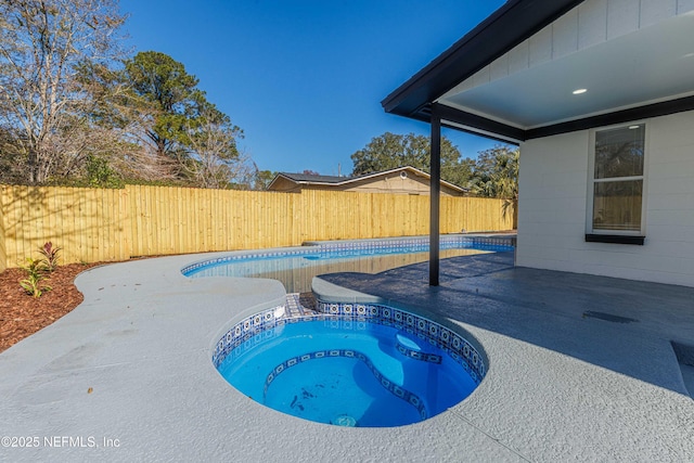 view of pool with an in ground hot tub and a patio