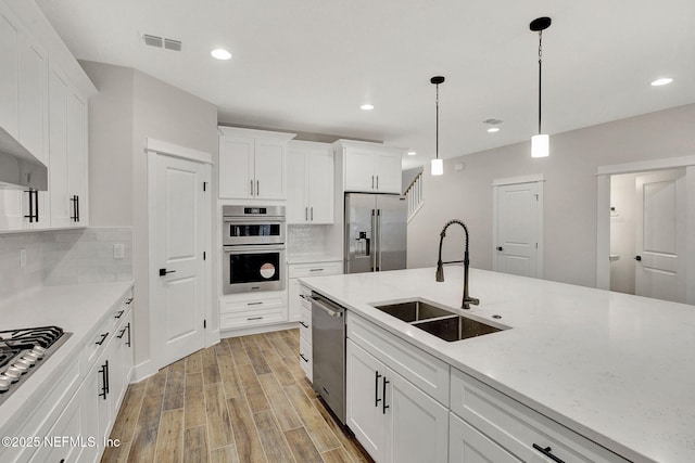 kitchen featuring sink, white cabinets, tasteful backsplash, and stainless steel appliances