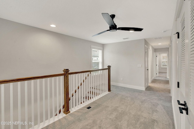 hall featuring light colored carpet