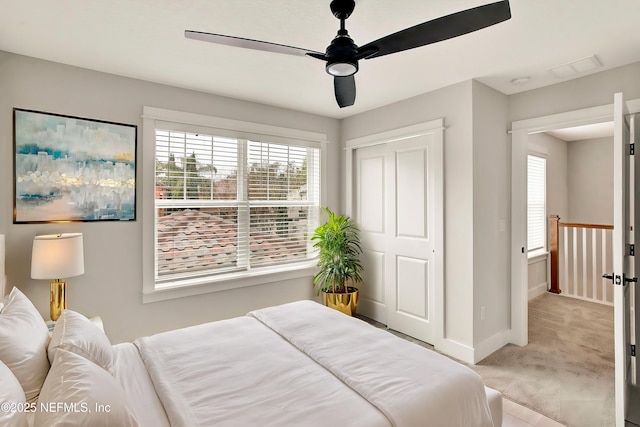 carpeted bedroom featuring a closet and ceiling fan