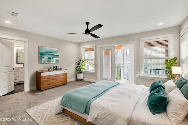 bedroom with light carpet, ensuite bath, and ceiling fan