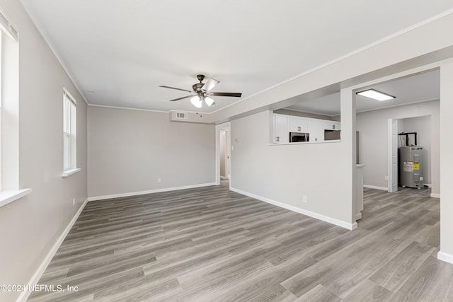 unfurnished room featuring ceiling fan, light hardwood / wood-style floors, and electric water heater