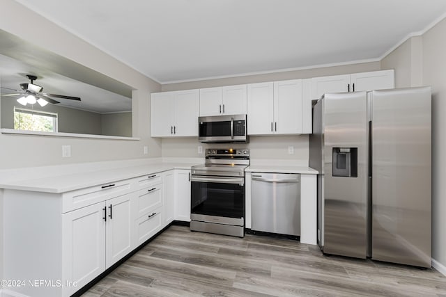 kitchen featuring white cabinets, appliances with stainless steel finishes, light hardwood / wood-style floors, ceiling fan, and crown molding