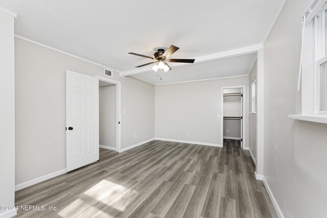 empty room with ceiling fan, ornamental molding, and hardwood / wood-style flooring