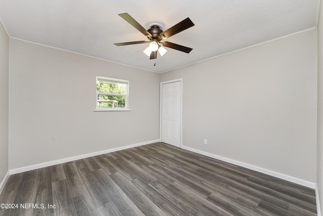 spare room featuring ceiling fan, dark wood-type flooring, and ornamental molding