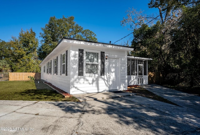 view of outbuilding with a sunroom and a lawn