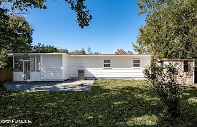 rear view of property with a patio area, a sunroom, a storage shed, and a yard