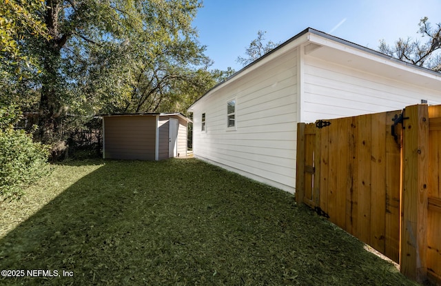 view of side of property with a lawn and a storage unit